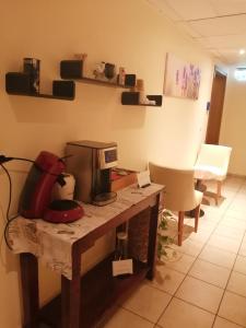 a kitchen with a table with a coffee maker on it at Hotel Princess in Rodenbach