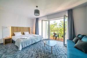 a hotel room with a bed and a couch at WYDMA Resort Medi & SPA - Normobaria in Mrzeżyno