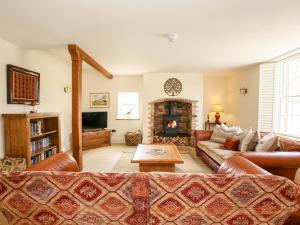 a living room with a couch and a fireplace at Shifford Manor Farm in Witney