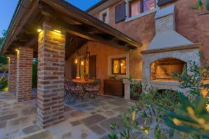 an outdoor patio with a fireplace and a table at Holiday House Ursa in Krk