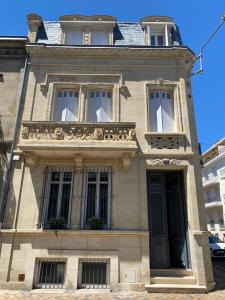 ein altes Gebäude mit Balkon und Tür in der Unterkunft La Villa Desvaux de Marigny in Bordeaux