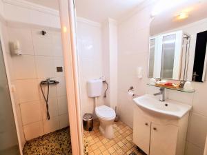 a white bathroom with a toilet and a sink at Hotel Elisabeta in Alba Iulia