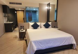 Postel nebo postele na pokoji v ubytování Golden City Rayong Hotel