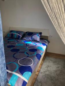 Mavrovo Twins Apartment في مافروفو: غرفة نوم مع سرير مع لحاف أرجواني وأزرق
