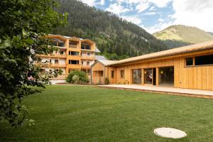 a building with a large lawn in front of it at Hotel Neusacherhof in Weissensee