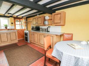a kitchen with a table and a table and a table and chairs at Caerau Farm House in Llanidloes