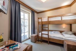 1 Schlafzimmer mit Etagenbetten und einem Schreibtisch in der Unterkunft Hotel Eden Rock in Bad Gastein