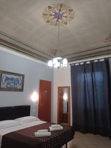 a bedroom with two beds and a chandelier at Adelaide House in Florence