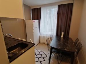 a small kitchen with a table and a refrigerator at Levent Apartments in Istanbul