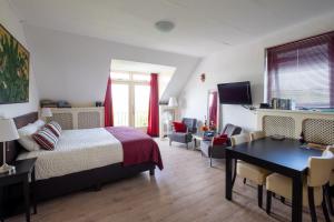 1 dormitorio con 1 cama, mesa y sillas en B&B Landleven, en Hellevoetsluis