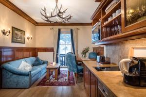 sala de estar con sofá azul y cocina en Villa Orania, en Bad Gastein