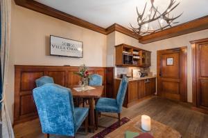 a dining room with a table and blue chairs at Villa Orania in Bad Gastein