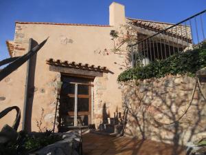 un edificio con puerta y pared de piedra en Masía Puigadoll, en Rodonyà