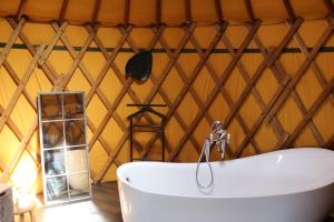 a bathroom with a tub in a yurt at yourtes coccinelles in Conchez-de-Béarn