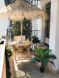 a table and chairs under a straw umbrella on a patio at Jacuzzi studio apartman Mare's in Zagreb