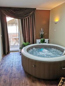 a large soaking tub in a room with a large window at Jacuzzi studio apartman Mare's in Zagreb
