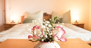 a vase filled with flowers on a table with a bed at Ferienhaus Mehlhartl in Tamsweg