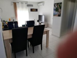 a dining room with a wooden table and black chairs at REZ DE VILLA SIX-FOURS in Six-Fours-les-Plages +16 photos