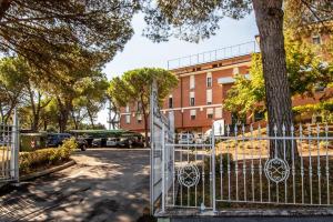 un cancello di fronte a un edificio con un albero di Fortuna Resort a Chianciano Terme