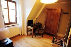 Habitación con escritorio, ordenador y ventana. en Hotel Zamek Lubliniec, en Lubliniec