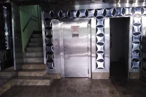 a metal elevator in a building with stairs at Hotel Barão De Tefé in Rio de Janeiro