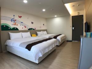 two beds in a room with a wall with butterflies at Music City Inn in Kaohsiung