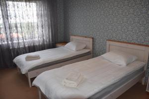 two twin beds in a room with a window at Uma Kuup Guest Apartments in Võru