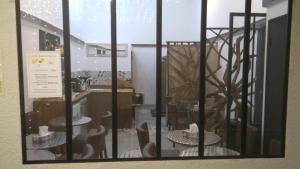 a window view of a kitchen with tables and chairs at Mauguio Center Hôtel in Mauguio