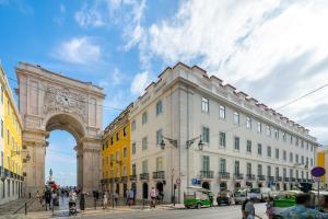 a building with an arch and people walking on a street at WHome | Prime Location Luxury Apartment in Lisbon
