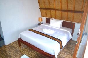 A bed or beds in a room at Lempeh Jungle Cottage
