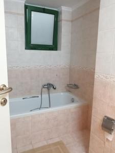 a bathroom with a bath tub with a window at Spacious Apartment in Nafplio City Center in Nafplio