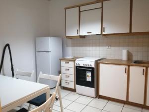 uma cozinha com electrodomésticos brancos e uma mesa com cadeiras em Spacious Apartment in Nafplio City Center em Nafplio