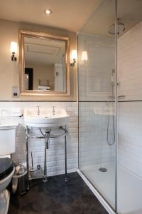 a bathroom with a sink and a shower and a mirror at The White Swan Hotel in Stratford-upon-Avon