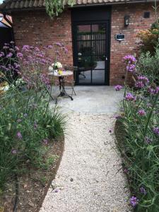 une terrasse avec une table et des fleurs devant un bâtiment dans l'établissement B&B Sint-Mariaburg, à Anvers