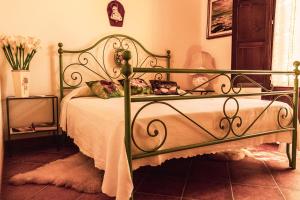 ein Schlafzimmer mit einem Bett mit einem grünen Rahmen in der Unterkunft Agriturismo Il Marrucheto in Scala Santa
