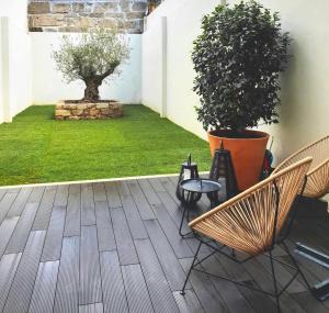 une terrasse avec deux chaises et une plante en pot dans l'établissement Stayin Apartments - Rua do Sol, à Porto