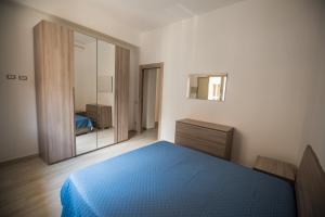 een slaapkamer met een blauw bed en een spiegel bij CASA STELLA in Comiso