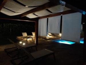eine Terrasse mit Stühlen und ein Pool in der Nacht in der Unterkunft Relais Juliette in La Morra