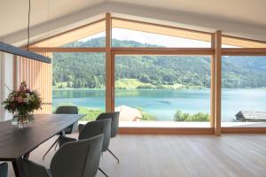 a dining room with a large view of a lake at Hotel Neusacherhof in Weissensee