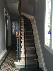 a staircase in a house with black and white floors and windows at La Villa Desvaux de Marigny in Bordeaux