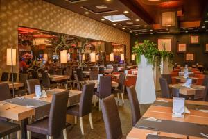 a dining room with wooden tables and chairs at Platinum Hotel & Casino in Sunny Beach