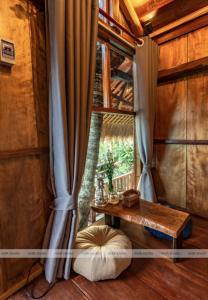 een woonkamer met een tafel en een raam bij Cat Homestay in Hue