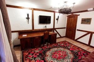 a room with a desk and a television and a rug at Vila Etnica in Trebujeni