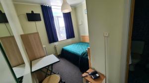 a small room with a bed and a window at hotel Melissa in Péruwelz