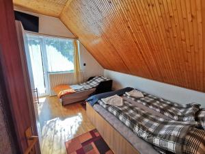 1 dormitorio con 2 camas y techo de madera en Country Vendégház, en Szilvásvárad