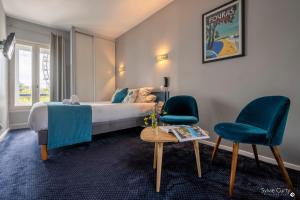 1 dormitorio con 1 cama, 2 sillas y mesa en Un Hotel sur le Port, en La Rochelle