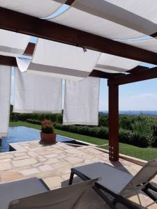 eine Terrasse mit 2 Stühlen und einem Sonnenschirm in der Unterkunft Relais Juliette in La Morra