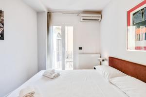 ein weißes Schlafzimmer mit einem Bett und einem Fenster in der Unterkunft Piazza Santa Croce Design Apartment with Balcony in Florenz