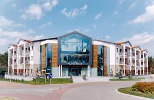 a building with a glass facade on a street at Morski Widok in Krynica Morska