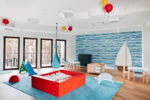 sala de estar con sofá rojo y alfombra azul en Morski Widok en Krynica Morska